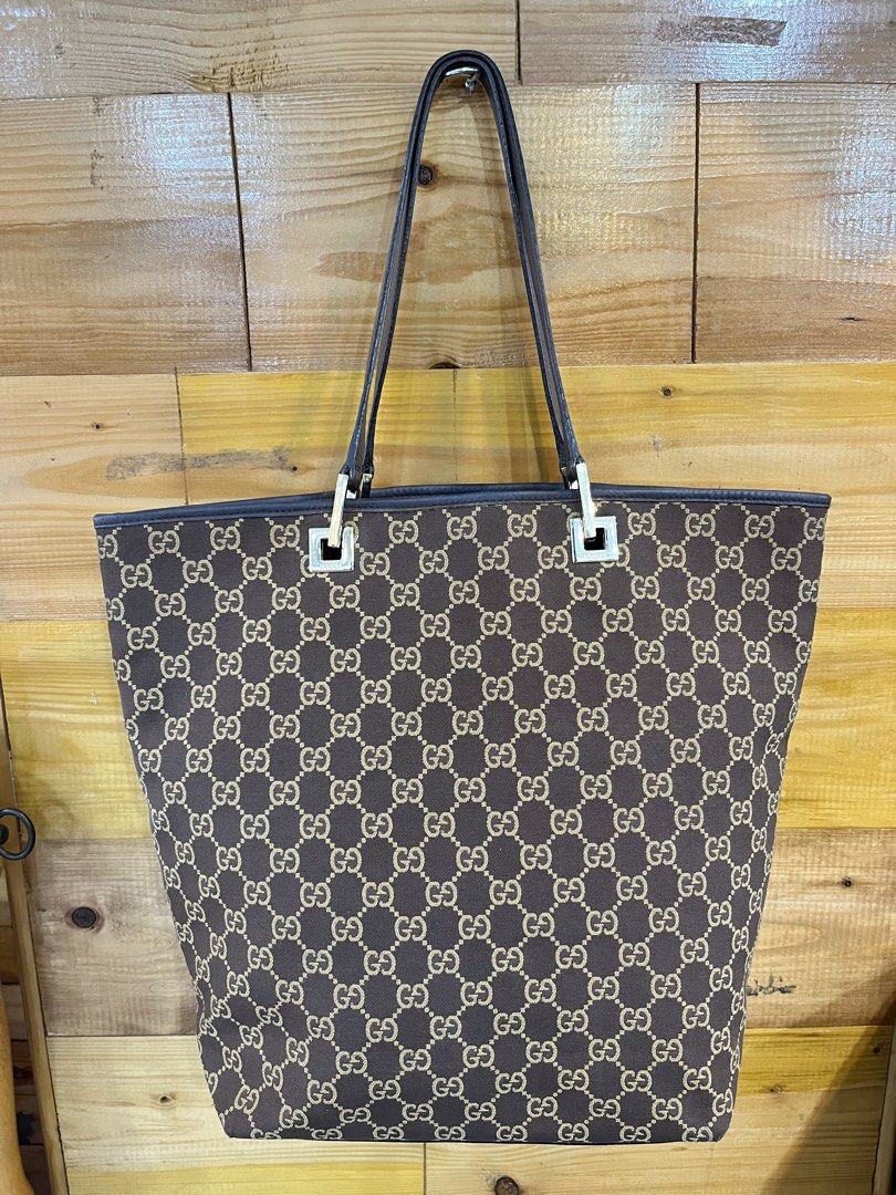 Gucci GG Canvas Tote Bag (Category: Tote Bags) located in Baguio. Submitted by elcie.08 (Listing ID 1469475567, Image 1). Description: - Authentic Gucci GG monogram canvas tote in classic brown - Dark brown leather trim and comfortable dual top handles - Elegant square hardware accents stamped with the brand name - Clean fabric interior lining with a zipped pocket - Includes classic leather heat stamp tag with serial numbers - Spacious and stylis