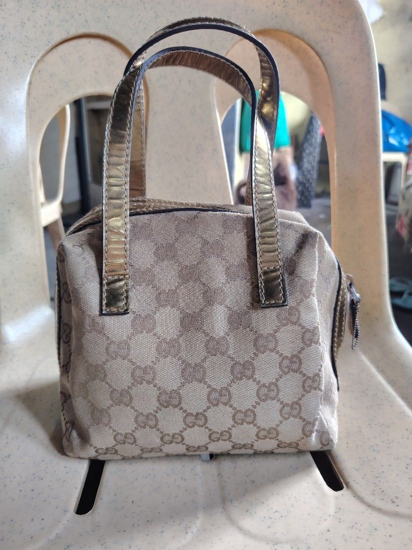Gucci GG Monogram Canvas Gold Trim Mini Handbag (Category: Luxury Bags & Wallets) located in Manila. Submitted by tabuzomaria1422 (Listing ID 1469411392, Image 1). Description: - Brand: Gucci - Material: Classic GG monogram canvas with metallic gold leather trim - Closure: Secure top zipper with gold pull tab - Interior: Patterned fabric lining with brand patch - Features: Dual top handles, compact structured shape for everyday essentials - Condi