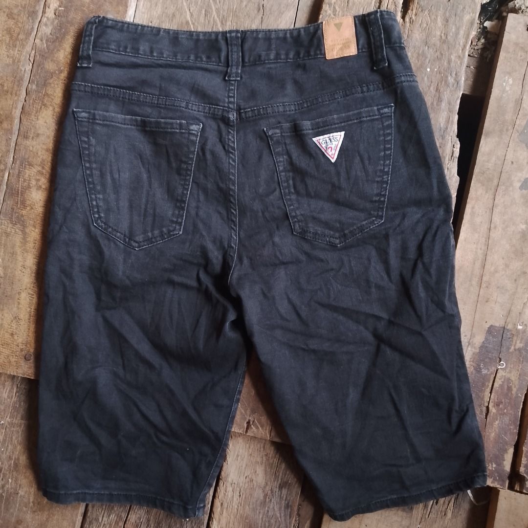Guess Black Denim Shorts Size 26 (Category: Shorts) located in Caloocan City. Submitted by alfepangasate1021 (Listing ID 1469439426, Image 1). Description: - Brand: Guess - Color: Washed black - Size: 70 (approx. US 26) - Fit: Mid-rise with standard button and zip closure - Style: Classic 5-pocket setup with iconic Guess triangle logo on the back pocket - Details: Branded leather patch on rear waistband - Material: 80% cotton, 19% polyester, 1% s