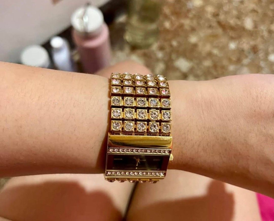 Guess gold rhinestone statement watch (Category: Women's Watches) located in Cebu City. Submitted by micaverzosa30 (Listing ID 1469509522, Image 3). Description: - Brand: Guess - Color/Finish: Gold tone - Style: Wide cuff bracelet with rhinestone encrusting - Dial: Rectangular dark dial with gold hands and Guess branding - Details: Sparkling rhinestone rows bordering the face - Condition: Works great, noticeable statement bling, no issue or damag
