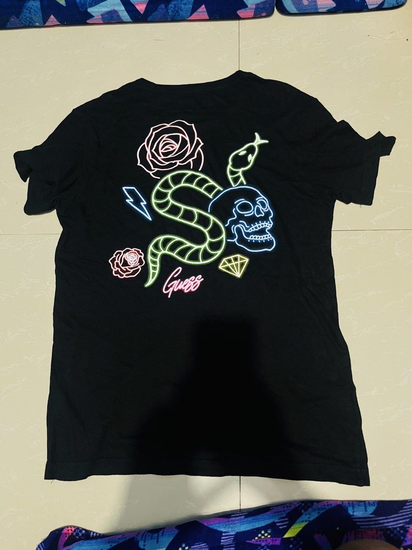 Guess Los Angeles Graphic Tee (Category: Tshirts & Polo Shirts ) located in Manila. Submitted by athan0800 (Listing ID 1469483992, Image 2). Description: - Brand: Guess Los Angeles - Color: Black - Size: Small - Fit: Standard fit with short sleeves and crew neck - Design: Minimalist chest branding with a bold, colorful neon graphic on the back (snake, skull, roses, lightning, and diamond) - Condition: Excellent / Well-maintained - Mode of Payment