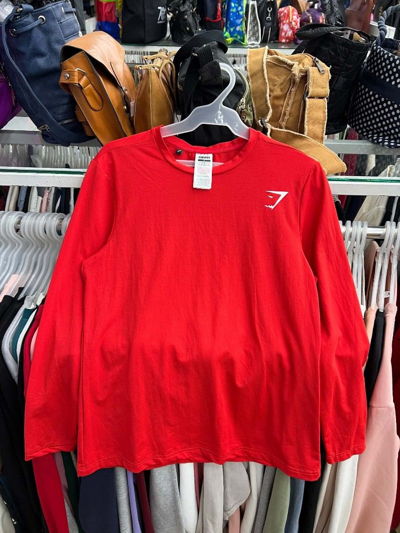 Gymshark Red Long Sleeve Workout Top (Category: Longsleeves) located in Urdaneta. Submitted by jayceegarage (Listing ID 1469543408, Image 1). Description: - Brand: Gymshark - Color: Red - Size: Small - Material: 90% Polyester, 10% Elastane - Features: Breathable micro-perforated fabric, white logo on chest, crew neck with inner branding - Condition: Great activewear piece for workouts and training.