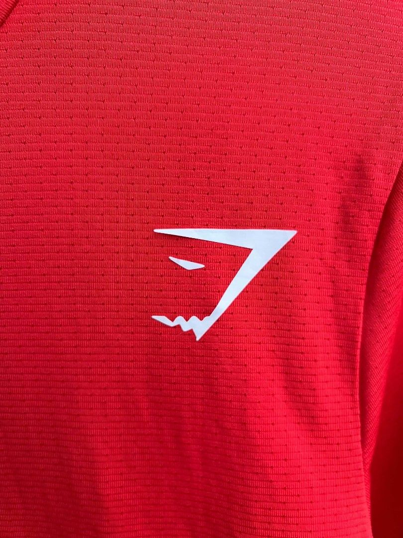 Gymshark Red Long Sleeve Workout Top (Category: Longsleeves) located in Urdaneta. Submitted by jayceegarage (Listing ID 1469543408, Image 2). Description: - Brand: Gymshark - Color: Red - Size: Small - Material: 90% Polyester, 10% Elastane - Features: Breathable micro-perforated fabric, white logo on chest, crew neck with inner branding - Condition: Great activewear piece for workouts and training.