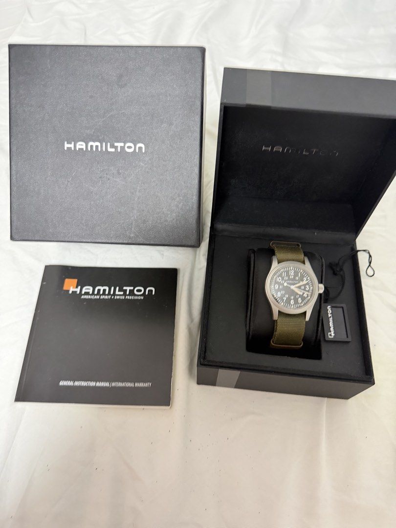 Hamilton Khaki Field Mechanical Watch (Category: Men's Watches) located in Arayat. Submitted by cjscolis (Listing ID 1469527449, Image 1). Description: - Authentic Hamilton Khaki Field mechanical watch - Classic black dial with easy-to-read military-style numerals - Reliable manual-wind movement - Comes with a green NATO strap plus an extra grey replacement strap - Complete with original presentation box, outer box, hang tag, and instruction manu