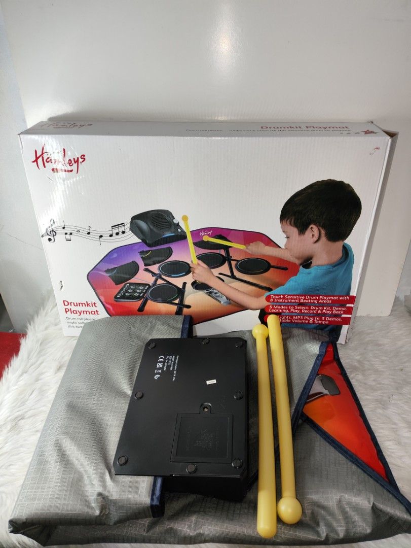 Hamleys Drumkit Playmat Touch Sensitive Toy with Drumsticks (Category: Kids Toys) located in Cavite. Submitted by tinetaclesss (Listing ID 1469509210, Image 1). Description: - Brand: Hamleys Drumkit Playmat - Interactive toy with touch-sensitive areas and 8 instrument zones - 5 modes: Drum kit, demo, learning, play, record, and play back - Built-in lights, adjustable volume, and tempo - MP3 plug-in compatible - Operates on 4 AA batteries - Includ