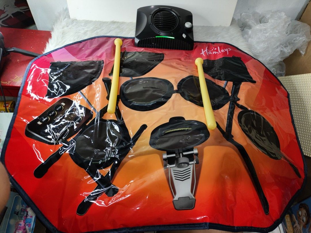 Hamleys Drumkit Playmat Touch Sensitive Toy with Drumsticks (Category: Kids Toys) located in Cavite. Submitted by tinetaclesss (Listing ID 1469509210, Image 2). Description: - Brand: Hamleys Drumkit Playmat - Interactive toy with touch-sensitive areas and 8 instrument zones - 5 modes: Drum kit, demo, learning, play, record, and play back - Built-in lights, adjustable volume, and tempo - MP3 plug-in compatible - Operates on 4 AA batteries - Includ