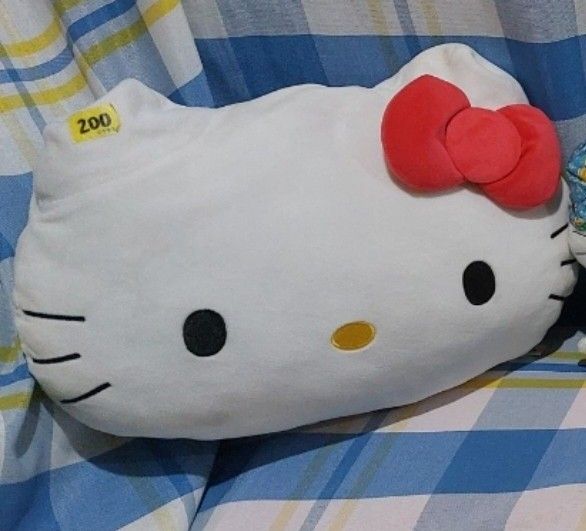 Hello Kitty Head Shaped Plush Pillow (Category: Plushies & Soft Toys) located in Mandaluyong City. Submitted by 13thsilverrabbit (Listing ID 1469461609, Image 1). Description: - Authentic Kitty shaped throw pillow in soft white - Features her classic red bow, embroidered eyes, nose, and whiskers - Standard couch cushion size - Clean fabric with firm, supportive stuffing - Original yellow price tag still attached - Perfect for bedrooms, living roo