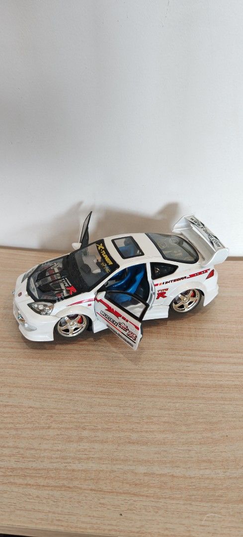 Honda Integra Type R Custom Diecast Model Car (Category: Vehicle & Diecast Models) located in Manila. Submitted by wilbert.lua (Listing ID 1469485524, Image 2). Description: - Custom white Honda Integra Type R collectible toy car - Eye-catching Mugen and X-Tuner graphics - Features opening doors and detailed engine under hood and rear glass - Styled with a rear spoiler, gold wheels, and striking blue interior seats - Must-have piece for JDM enthu
