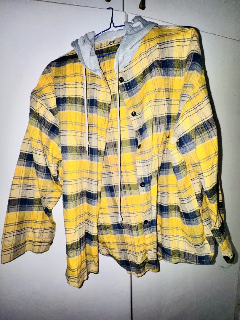 Hooded Plaid Flannel Shirt (Category: Coats, Jackets and Outerwear) located in Valenzuela. Submitted by styledtwicethriftshop (Listing ID 1469490134, Image 3). Description: Button-down flannel shirt with an attached grey hood and drawstring. Plaid pattern in blue, black, and white tones. Long sleeves with button cuffs. Regular fit, easy to layer over tees. Fabric feels soft and lightweight..