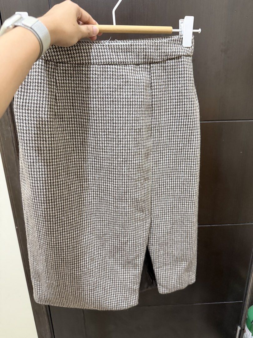 Houndstooth Midi Skirt with Front Slit (Category: Skirts) located in Taguig. Submitted by purelyprelovedgems (Listing ID 1469417161, Image 2). Description: - Style: Brown and white houndstooth midi skirt - Fit: Straight cut with a high waist design - Details: Small front slit at the bottom hem and side zipper closure - Comfort: Fully lined interior - Occasion: Versatile for work or casual outings.