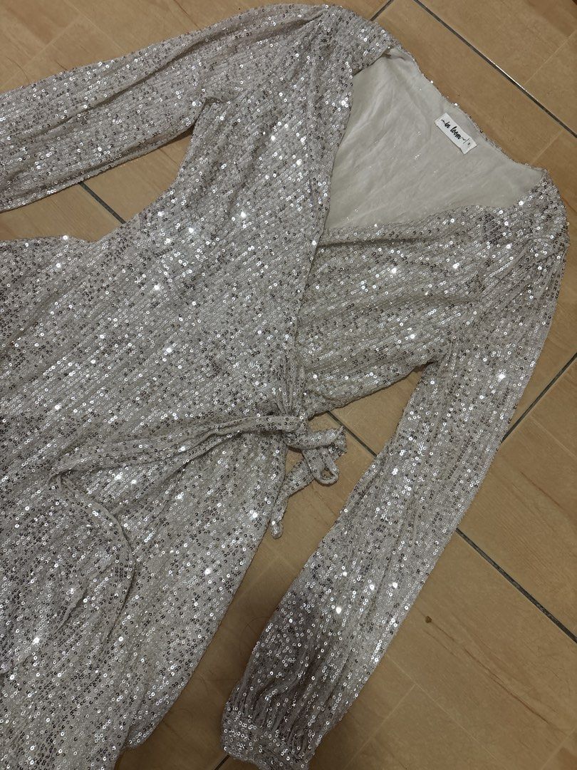 In Loom Silver Sequin Wrap Dress Long Sleeve (Category: Dresses) located in Cabuyao City. Submitted by airpz (Listing ID 1469433744, Image 2). Description: - Brand: In Loom - Style: Silver sequin wrap dress with V-neckline and self-tie waist - Details: Long sleeves with button cuffs, fully lined, short length - Perfect for: Parties, dinners, and night outs.