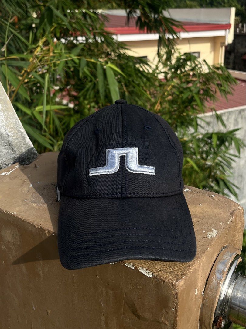 j.lindeberg Black Baseball Cap (Category: Caps & Hats) located in Pontevedra. Submitted by thrift01 (Listing ID 1469572041, Image 2). Description: - Brand: J.Lindeberg - Color: Black - Design: Iconic silver Bridge logo embroidered on front, brand name on back - Fit: Clean structured crown with curved visor - Details: Branded interior sweatband lining, made in China - Perfect for: Golf, sports, and casual everyday wear.