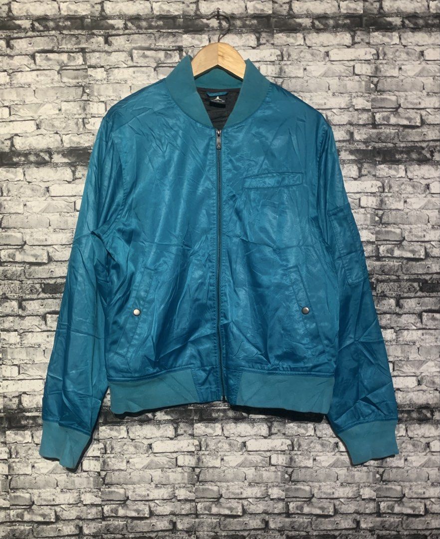 Jordan Blue Bomber Jacket (Category: Coats, Jackets and Outerwear) located in Manila. Submitted by marksaban81396 (Listing ID 1469549214, Image 3). Description: Size large Width 21 Lenght 27 Color rate 9 No issue excellent concc F- Brand: Jordan - Color: Teal blue - Closure: Full zip front - Details: Ribbed collar, cuffs, and hem - Pockets: Front snap-button pockets plus a left sleeve utility pocket - Interior: Dark lining with Jordan branding - 