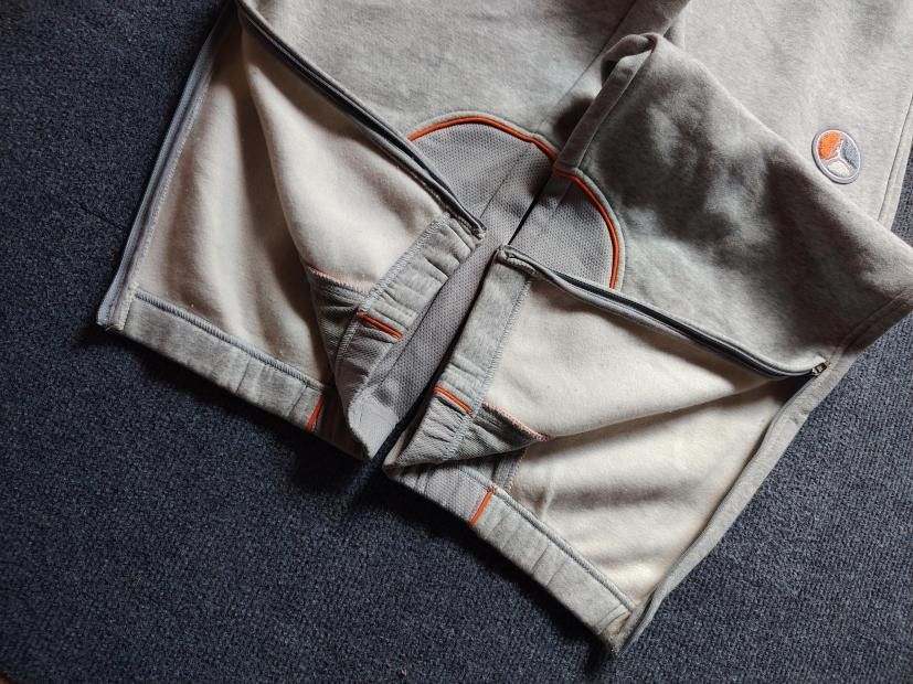 Jordan Grey Fleece Sweatpants Size M (Category: Joggers) located in Manila. Submitted by carldavebanay (Listing ID 1469554560, Image 2). Description: - Brand: Jordan - Color: Grey with orange trim accents - Size: Medium (tag attached) - Material: Soft interior fleece lining for maximum warmth - Features: Adjustable drawstring waistband, side pockets, and a secure buttoned back pocket - Details: Unique circular patch on the left leg - Cuffs: Ribbe