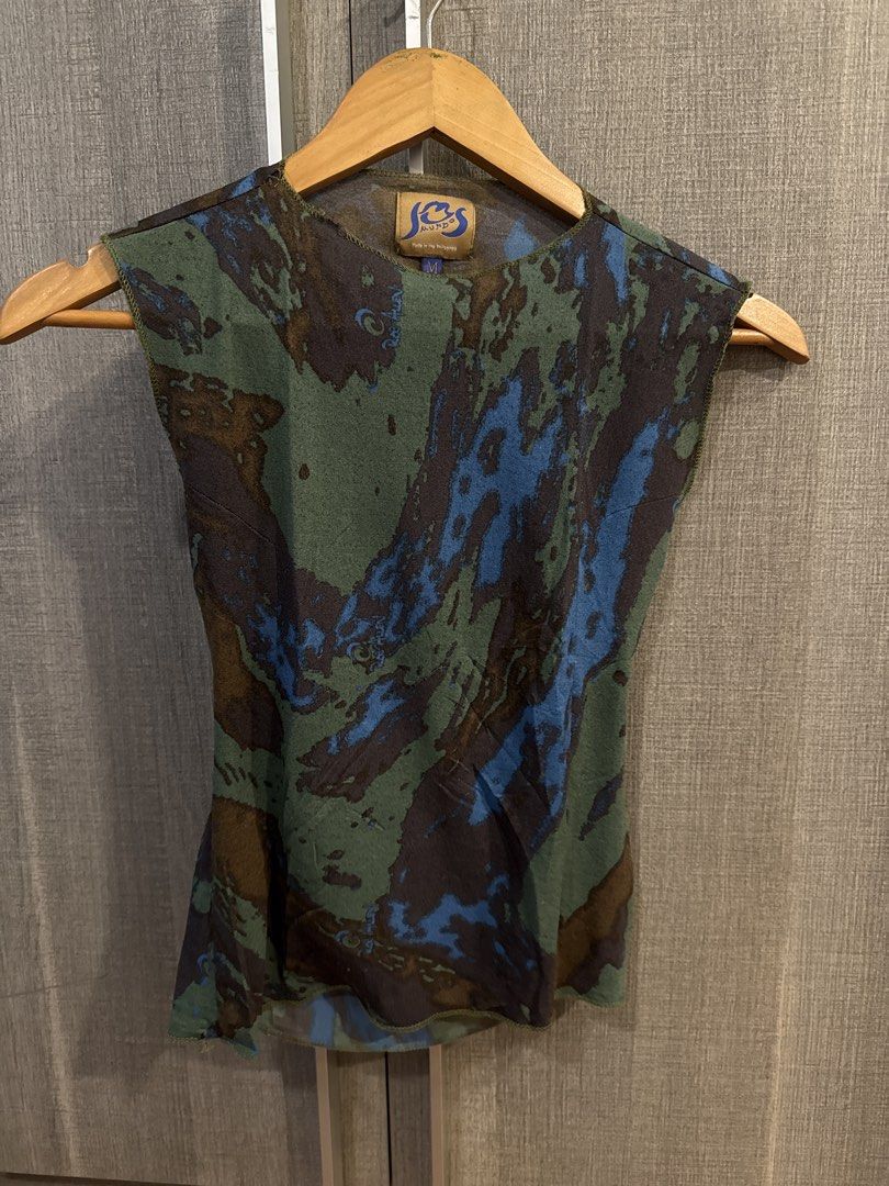 JOS Mundo Top (Category: Sleeveless) located in Makati City. Submitted by kkk.shops (Listing ID 1469510008, Image 1). Description: - Brand: JOS Mundo - Size: M - Design: Blue, green, and brown abstract camo-style pattern - Details: Round front neckline, low cowl back cutout, lightweight fabric, lettuce hem edges - Origin: Made in the Philippines - Versatility: Great for casual wear or night out styling.