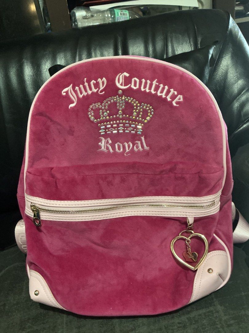 Juicy Couture Royal Velour Backpack Pink (Category: Backpacks) located in Santa Barbara. Submitted by user82739292 (Listing ID 1469441447, Image 2). Description: - Juicy Couture velour backpack in deep pink - Features signature rhinestone crown logo and embroidered text - Accentuated with light pink trim and corners - Premium gold-tone hardware with a cute heart-shaped zipper charm - Soft texture with a spacious main compartment - Perfect for dai