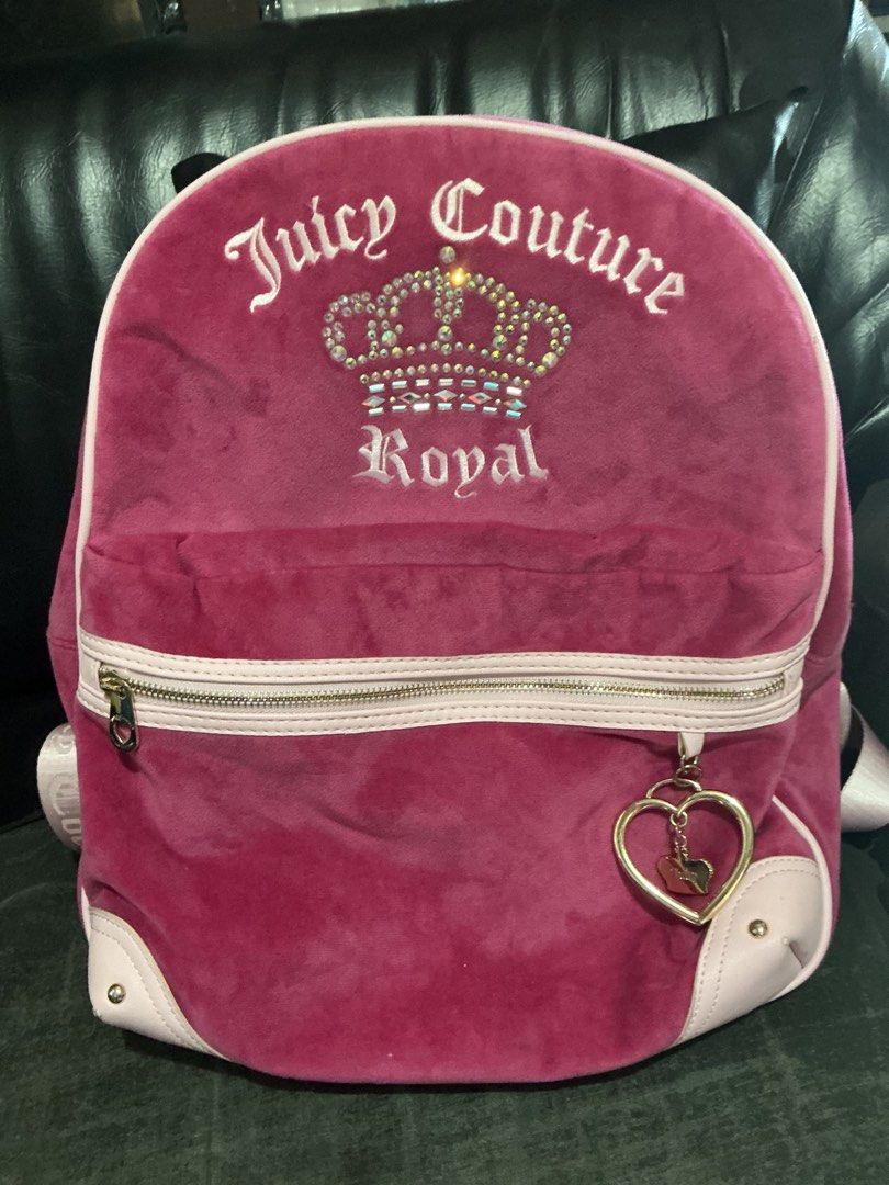 Juicy Couture Royal Velour Backpack Pink (Category: Backpacks) located in Santa Barbara. Submitted by user82739292 (Listing ID 1469441447, Image 1). Description: - Juicy Couture velour backpack in deep pink - Features signature rhinestone crown logo and embroidered text - Accentuated with light pink trim and corners - Premium gold-tone hardware with a cute heart-shaped zipper charm - Soft texture with a spacious main compartment - Perfect for dai