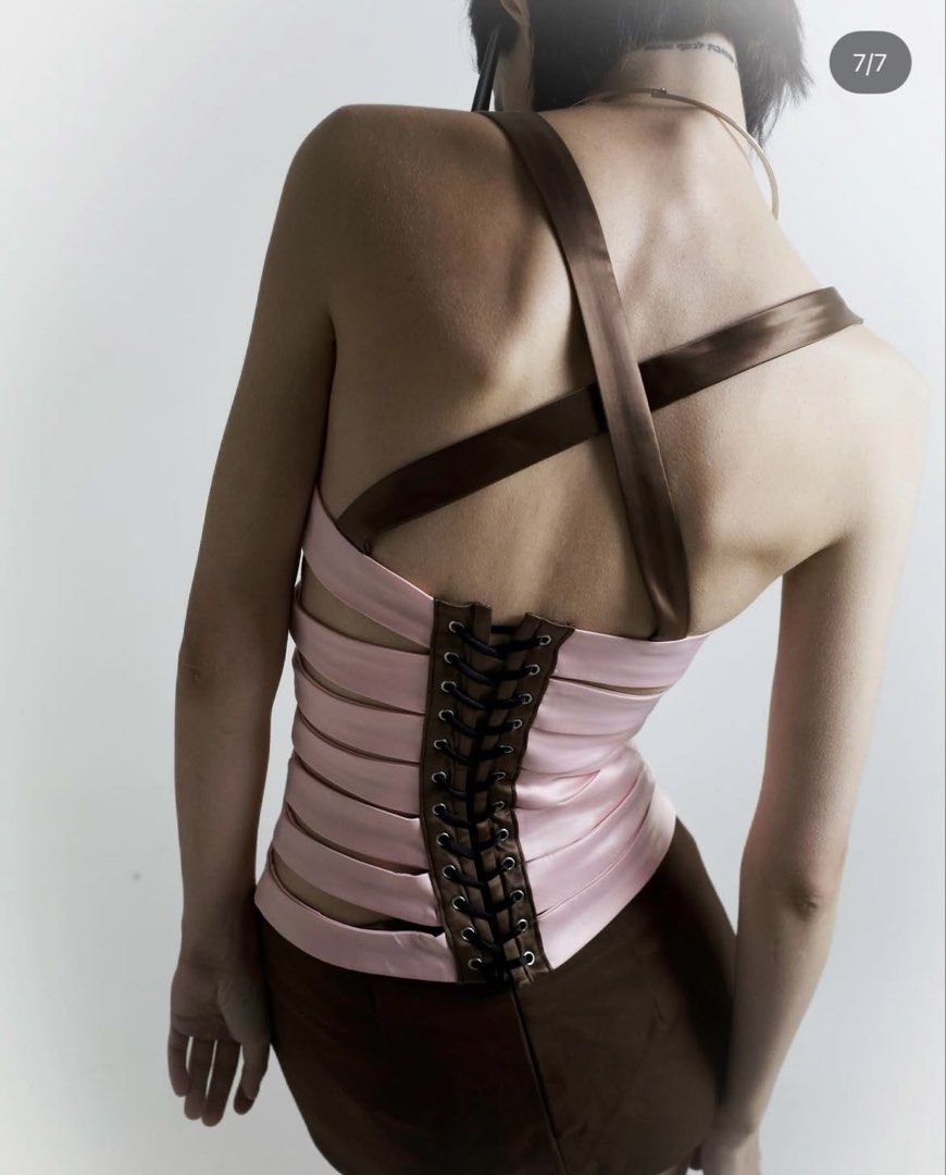 Kae Lupe Bandage Top (Category: Sleeveless) located in Paranaque City. Submitted by amdrs (Listing ID 1469476948, Image 2). Description: Size M RFS: Does not fit me Super Brand New :) Pasabuyed from Vietnam - Pink satin corset style top with brown contrast piping and straps - Features a layered panel construction with stylish front cutouts.