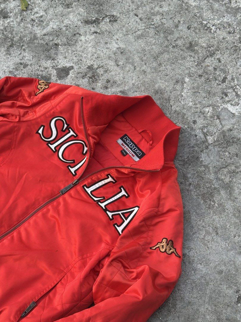 Kappa Sicilia Red Bomber Jacket (Category: Coats, Jackets and Outerwear) located in Bago City. Submitted by thekasproject (Listing ID 1469477151, Image 3). Description: - Color: Bright red - Size: Medium - Design: Sicilia lettering across the chest with quilted detailing on sleeves and sides - Branding: Embroidered Kappa logo patches on shoulders and back collar - Features: Full-zip front closure with ribbed collar, cuffs, and hem - Condition: Ex