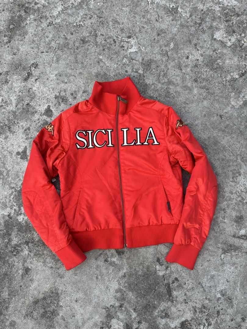 Kappa Sicilia Red Bomber Jacket (Category: Coats, Jackets and Outerwear) located in Bago City. Submitted by thekasproject (Listing ID 1469477151, Image 1). Description: - Color: Bright red - Size: Medium - Design: Sicilia lettering across the chest with quilted detailing on sleeves and sides - Branding: Embroidered Kappa logo patches on shoulders and back collar - Features: Full-zip front closure with ribbed collar, cuffs, and hem - Condition: Ex
