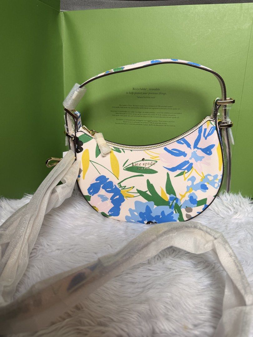 Kate Spade Floral Crescent Shoulder Bag (Category: Shoulder Bags) located in Rizal. Submitted by gannda (Listing ID 1469440625, Image 1). Description: - Brand: Kate Spade - Condition: Brand new with tags (never used) - Design: Blue & yellow floral pattern on off-white - Style: Curved crescent shoulder bag - Hardware: Gold-tone - Closure: Top zip - Strap: Includes detachable & adjustable matching strap for crossbody wear - with paper bag or box.