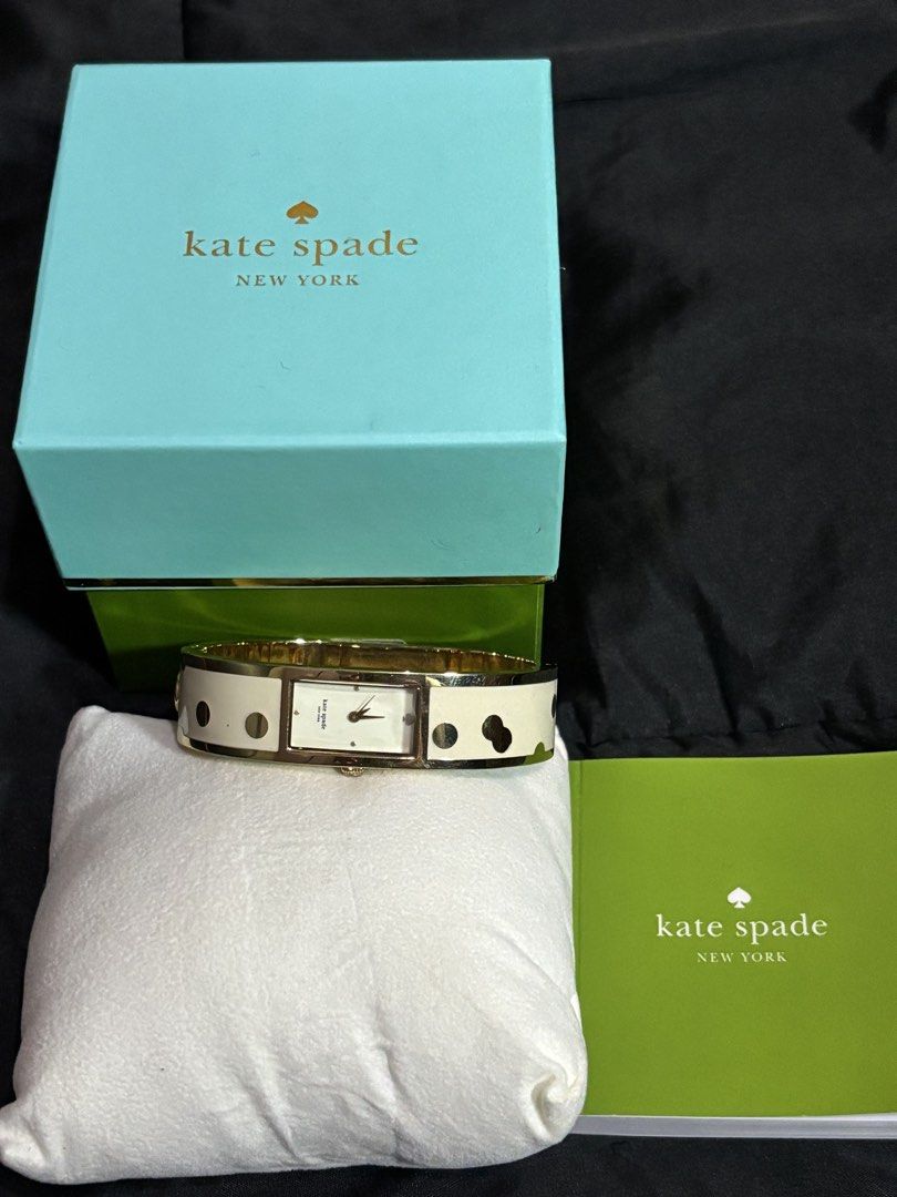 Kate Spade New York Confetti Carousel Bangle Watch (Category: Women's Watches) located in Caloocan City. Submitted by berndale_closet (Listing ID 1469570041, Image 2). Description: - Brand: Kate Spade New York (Confetti Carousel Bangle Watch) - Dial: Rectangular cream-white analog with signature spade logo at 12 o'clock - Case: Gold-plated stainless steel (16mm width) - Strap: Rigid hinged gold-tone bangle inlaid with ivory enamel and gold polka 