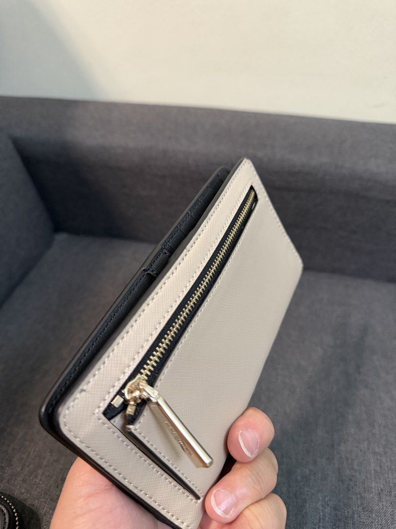 Kate Spade Staci Colorblock Large Slimfold Wallet (Category: Wallets & Card holders) located in Quezon City. Submitted by pam07pam (Listing ID 1469481443, Image 3). Description: - Authentic Kate Spade Staci Large Slimfold Wallet - Color: Warm Beige and Black Colorblock - Material: Durable Saffiano Leather - Features multiple card slots, clear ID window, and secure snap closure - Convenient exterior zip pocket on the back - Brand new with original