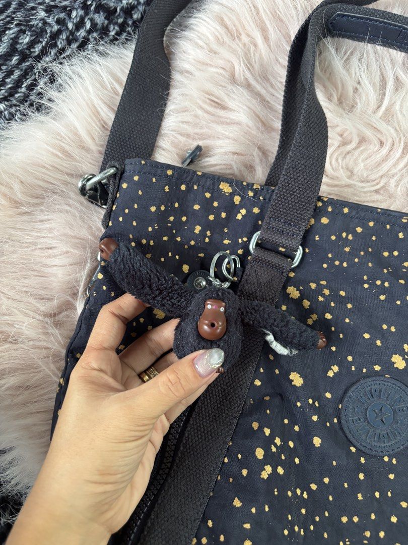 Kipling Black Gold Splatter Tote Bag (Category: Tote Bags) located in Digos. Submitted by kathydiane76376 (Listing ID 1469427782, Image 3). Description: - Brand: Kipling - Color/Design: Classic black with stylish gold splatter pattern - Material: Durable, lightweight nylon - Straps: Dual top handles + adjustable, detachable shoulder strap - Pockets: Multiple exterior zip pockets for easy organization - Closure: Secure top zip main compartment - I