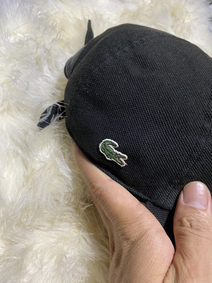 Lacoste Black Cap (Category: Caps & Hats) located in Badiangan. Submitted by iralorana.thrift (Listing ID 1469419329, Image 2). Description: - Brand: Lacoste - Color: Classic Black - Design: Structured with a curved brim - Details: Iconic embroidered green crocodile on the side and Lacoste lettering on the back strap - Fit: Adjustable strap closure for a custom fit - Condition: Clean fabric with minimal signs of wear.