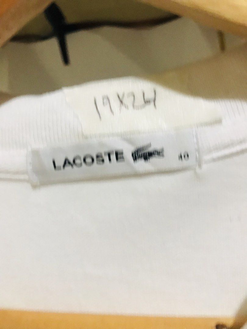 Lacoste White Polo Shirt Size 40 Devanlay (Category: Luxury Apparel) located in Rizal. Submitted by drthriftone (Listing ID 1469572312, Image 3). Description: - Brand: Lacoste - Color: White - Size: 40 - Details: Classic collar, short sleeves, ribbed cuffs - Hardware: Mother-of-pearl buttons with engraved branding - Logo: Iconic embroidered green crocodile on the chest - Authenticity: Includes Devanlay care tag inside - Condition: Clean, crisp fa
