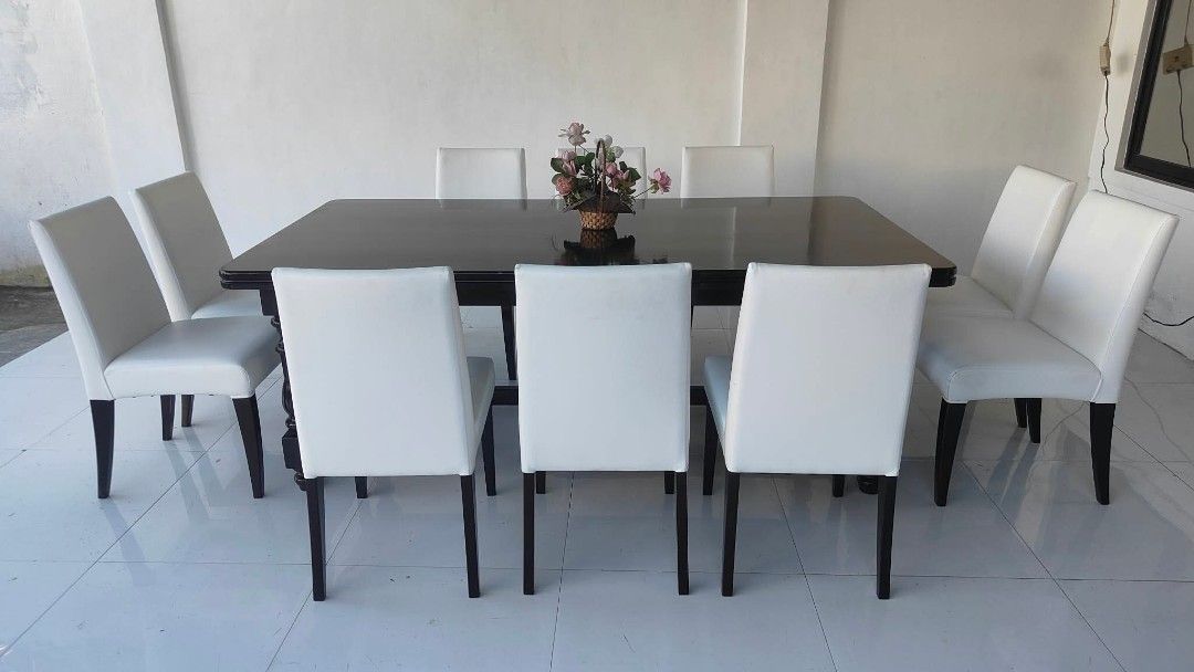 Large dark wood dining table with eight white chairs (Category: Tables & Sets) located in Manila. Submitted by roveeeeelen_06 (Listing ID 1469418864, Image 1). Description: - Elegant rectangular dining table with a dark polished wood finish - Includes 8 matching high-back chairs upholstered in smooth white synthetic leather - Sturdy frame that comfortably seats 8 people, ideal for family gatherings - Overall clean upholstery - Minor scuffs on tab