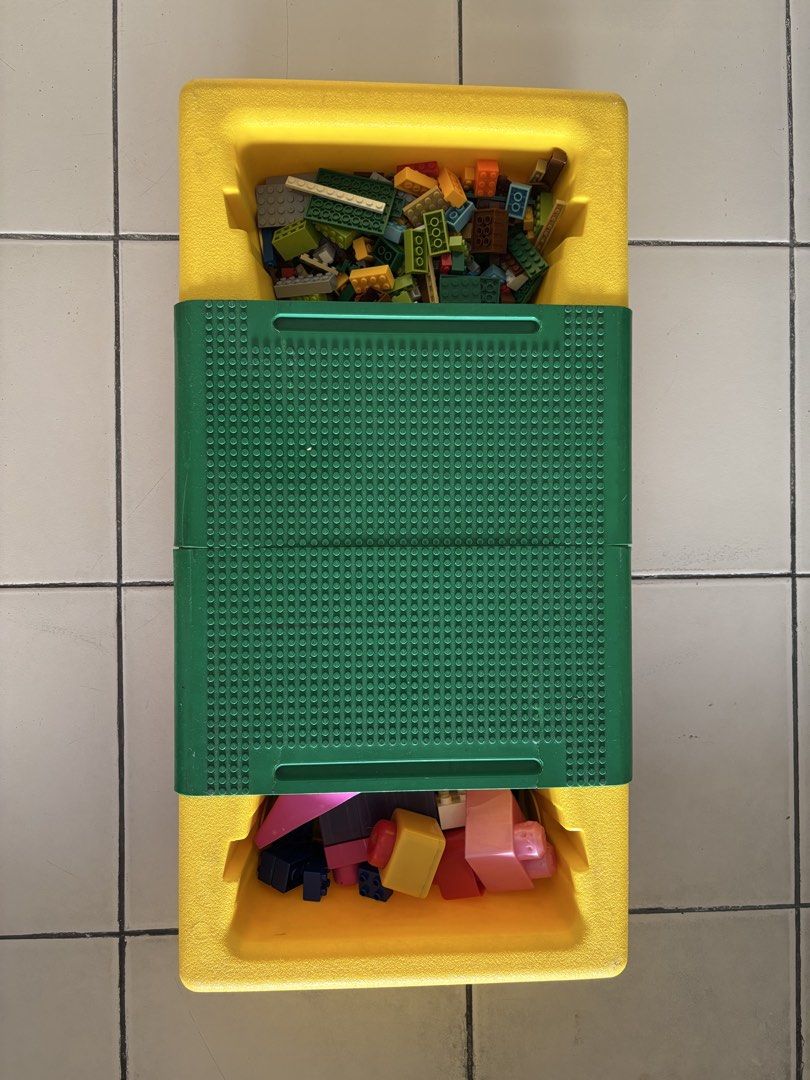 LEGO Play Table with Storage Compartments and Bricks (Category: Lego & Building Sets) located in Quezon City. Submitted by msuyo (Listing ID 1469571062, Image 3). Description: - Vibrant yellow, green, and red LEGO play table with green baseplates on top - Built-in storage compartments on both ends to keep things organized - Comes with a mix of standard bricks and larger toddler blocks - Foldable red legs underneath for easy storage and portabilit