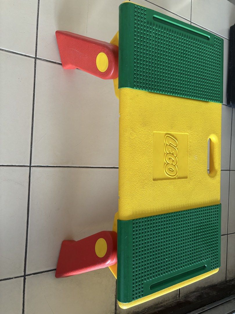 LEGO Play Table with Storage Compartments and Bricks (Category: Lego & Building Sets) located in Quezon City. Submitted by msuyo (Listing ID 1469571062, Image 2). Description: - Vibrant yellow, green, and red LEGO play table with green baseplates on top - Built-in storage compartments on both ends to keep things organized - Comes with a mix of standard bricks and larger toddler blocks - Foldable red legs underneath for easy storage and portabilit