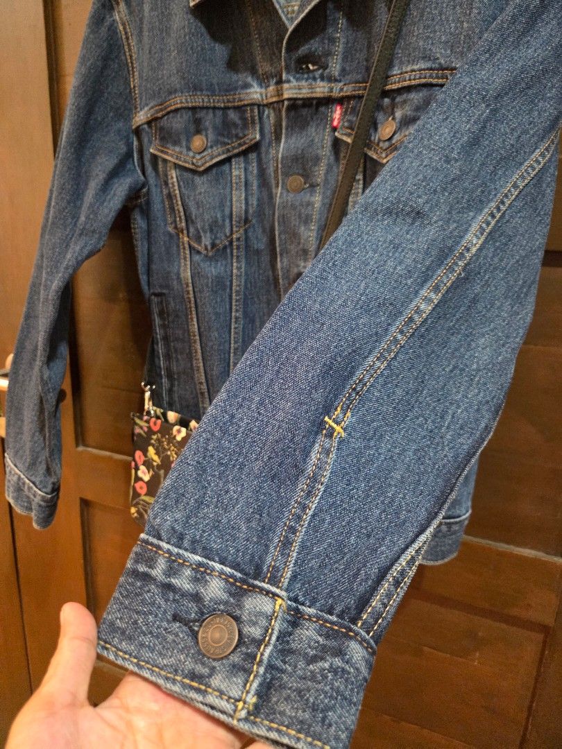 Levi's denim jacket size S (Category: Coats, Jackets and Outerwear) located in Manila. Submitted by mysticrabbit.284012 (Listing ID 1469480052, Image 3). Description: - Brand: Levi's - Style: Classic denim jacket - Color/Wash: Dark blue - Size: S - Details: Front button closure, branded metal hardware, two chest flap pockets, two side pockets - Branding: Red Levi's tab on chest pocket, tan leather patch on back collar - Origin: Made in Bangladesh