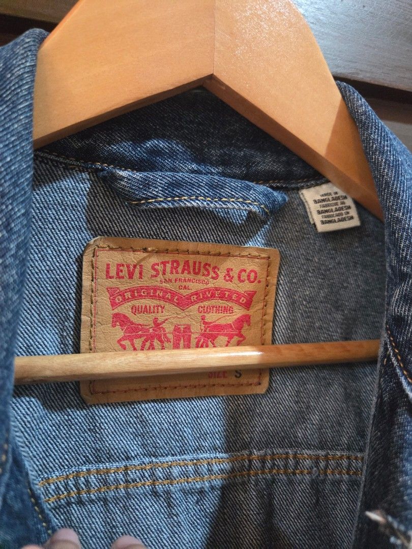 Levi's denim jacket size S (Category: Coats, Jackets and Outerwear) located in Manila. Submitted by mysticrabbit.284012 (Listing ID 1469480052, Image 2). Description: - Brand: Levi's - Style: Classic denim jacket - Color/Wash: Dark blue - Size: S - Details: Front button closure, branded metal hardware, two chest flap pockets, two side pockets - Branding: Red Levi's tab on chest pocket, tan leather patch on back collar - Origin: Made in Bangladesh