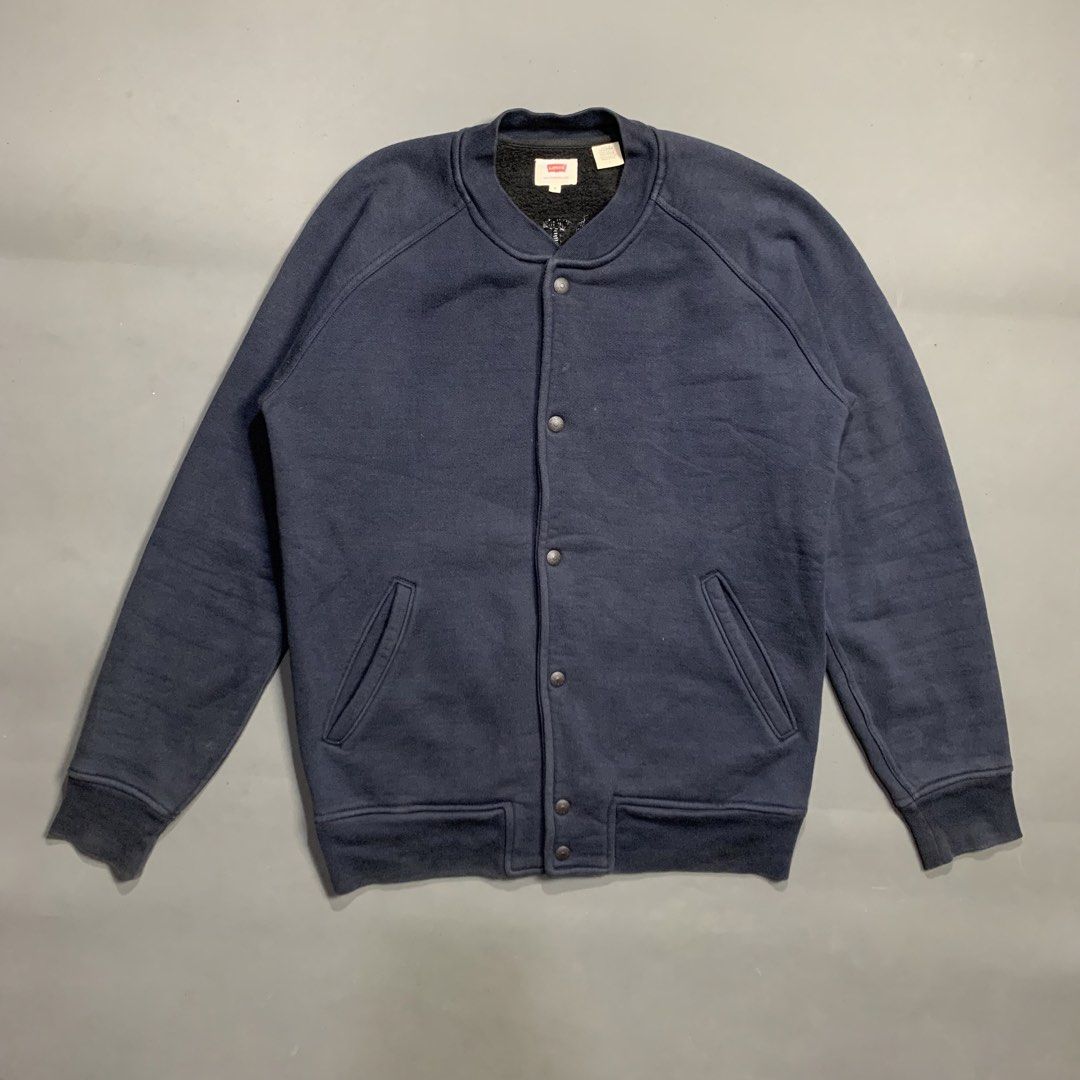 Levi's Navy Blue Bomber Fleece Jacket (Category: Coats, Jackets and Outerwear) located in Kalibo. Submitted by gneiss2002 (Listing ID 1469536105, Image 1). Description: - Brand: Levi's - Color: Navy blue with black sherpa fleece lining - Closure: Snap button front - Pockets: Two slant pockets at the waist - Details: Ribbed collar, cuffs, and hem - Style: Classic varsity cut, warm, and easy to match with any outfit.