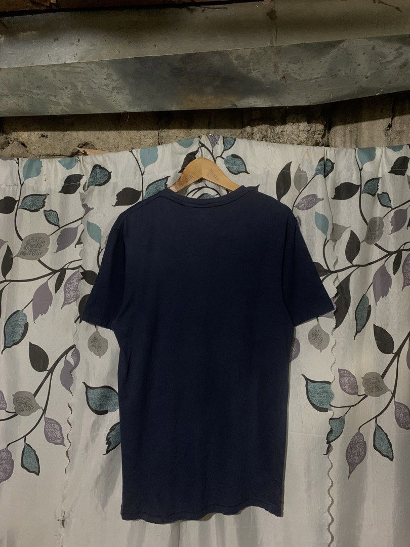 Levi's Navy Blue Graphic T-Shirt (Category: Shirts) located in Dumaguete. Submitted by grrrpowww (Listing ID 1469414692, Image 3). Description: - Brand: Levi's - Color: Dark blue with large red batwing chest logo - Size: M (Standard fit) - Design: Short sleeves, classic crew neck - Condition: Clean fabric overall, gently used - Product Code: 17783-0199.