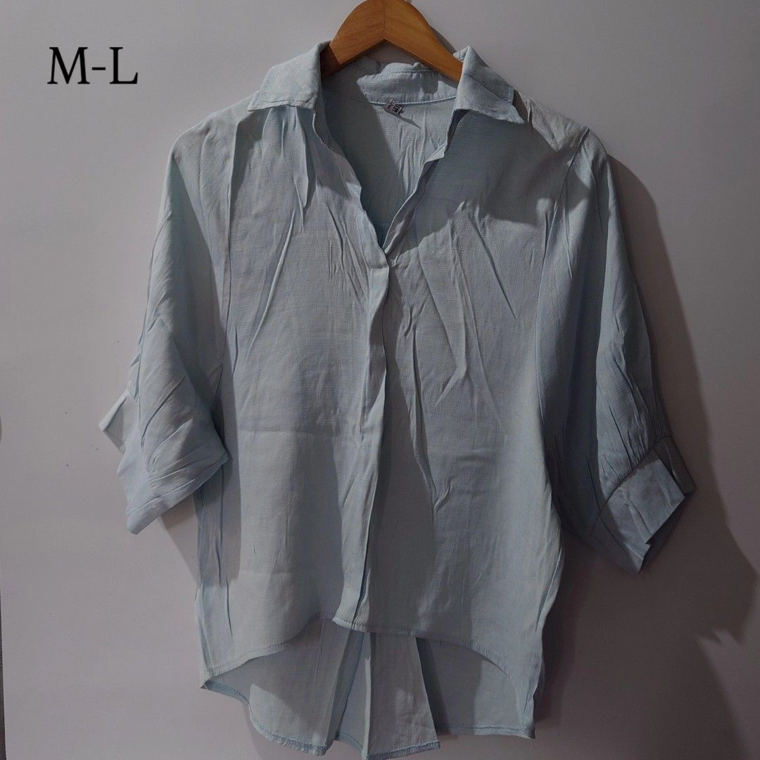Light blue button-up shirt high-low hem size M-L (Category: Shirts) located in Diffun. Submitted by declutteredbyJill (Listing ID 1469570445, Image 1). Description: - Color: Light blue - Size: Fits Medium to Large - Style: Button-up with collared neckline and 3/4 length sleeves - Fit: Relaxed fit with a trendy high-low curved hem at the back - Fabric: Lightweight and textured, ideal for effortless casual wear.