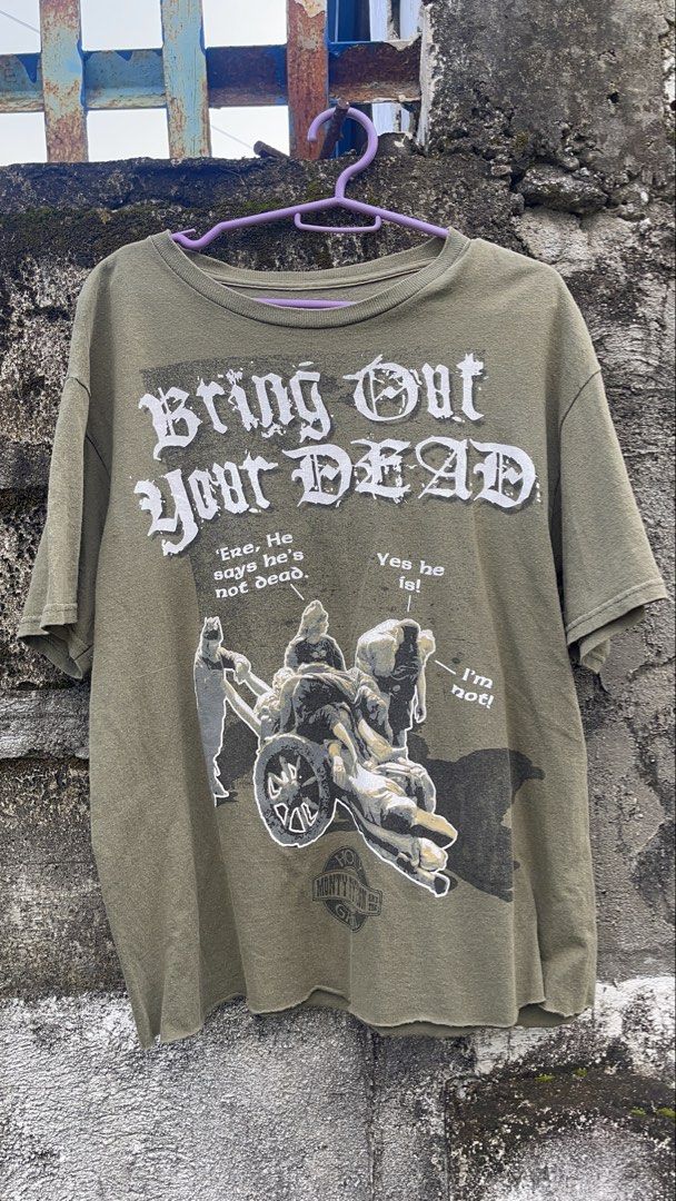 Liquid Blue Monty Python Bring Out Your Dead T-Shirt (Category: Tshirts & Polo Shirts ) located in Balanga. Submitted by death_vintage (Listing ID 1469476251, Image 1). Description: - Brand: Liquid Blue - Design: Iconic 'Bring Out Your Dead' plague cart graphic with classic Monty Python movie quotes - Color: Olive green - Size: Medium - Fit: Relaxed fit with a vintage graphic tee feel - Condition: Great piece for collectors and comedy fans.