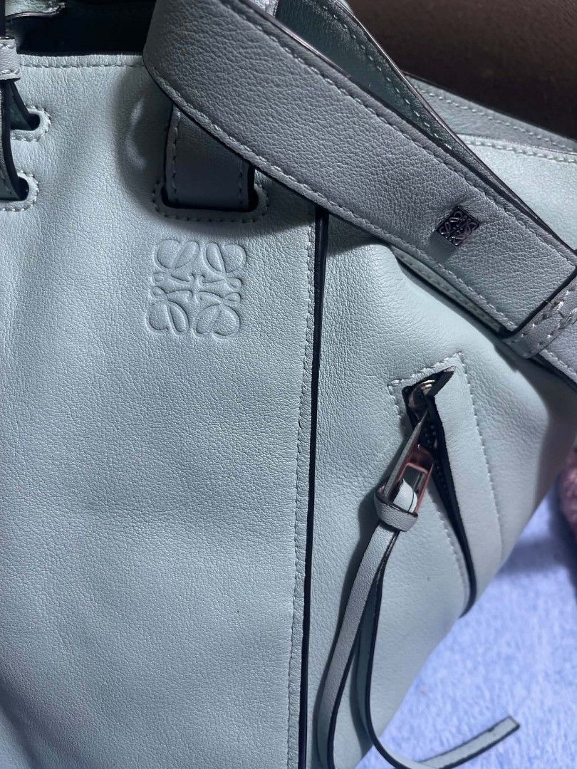 Loewe Hammock Small Smoke Blue 2-Way Handbag (Category: Shoulder Bags) located in Manila. Submitted by jjm-collections (Listing ID 1469400666, Image 3). Description: - Brand: Loewe - Style: Hammock Bag - Color: Smoke Blue - Material: Premium Leather - Dimensions: 9.8 x 12.2 x 5.3 inches - Versatility: Two-way design (shoulder bag or top handle tote) - Details: Side zip pocket with tassel pulls, debossed Anagram logo on front - Interior: Herringbo