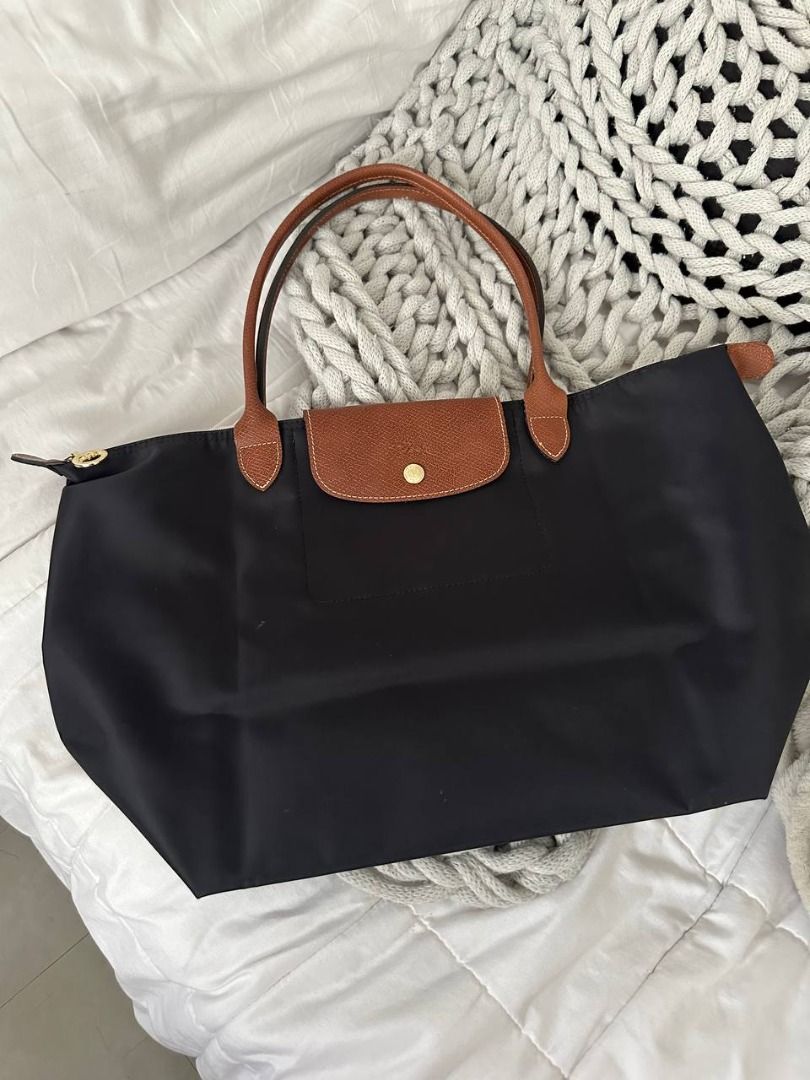 Longchamp Le Pliage Long Handle Tote Bag Black (Category: Luxury Bags & Wallets) located in Quezon City. Submitted by flipandfind (Listing ID 1469418478, Image 1). Description: - Longchamp Le Pliage Tote - Color: Classic Black nylon with rich brown leather handles and flap - Hardware: Gold-tone snap button and signature horse zipper pull - Closure: Top zip closure for added security - Interior: Spacious main compartment with a convenient small sl