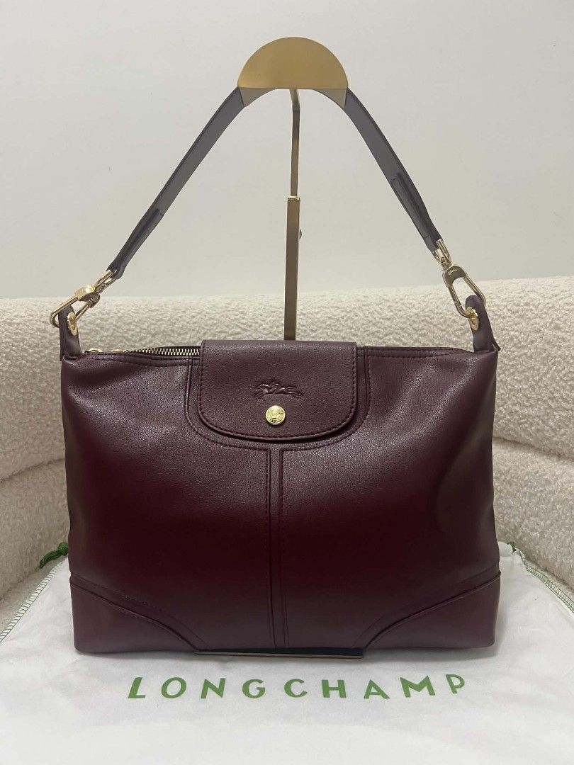 Longchamp Leather Shoulder Bag (Category: Shoulder Bags) located in Paoay. Submitted by rvf1230 (Listing ID 1469401930, Image 2). Description: - Brand: Longchamp - Color: Deep burgundy - Material: Premium leather with gold-tone hardware - Closure: Secure top zip closure - Exterior: Front flap pocket with iconic embossed horse logo - Strap: Single detachable shoulder strap - Interior: Clean interior with a structured base - Inclusion: Original dus