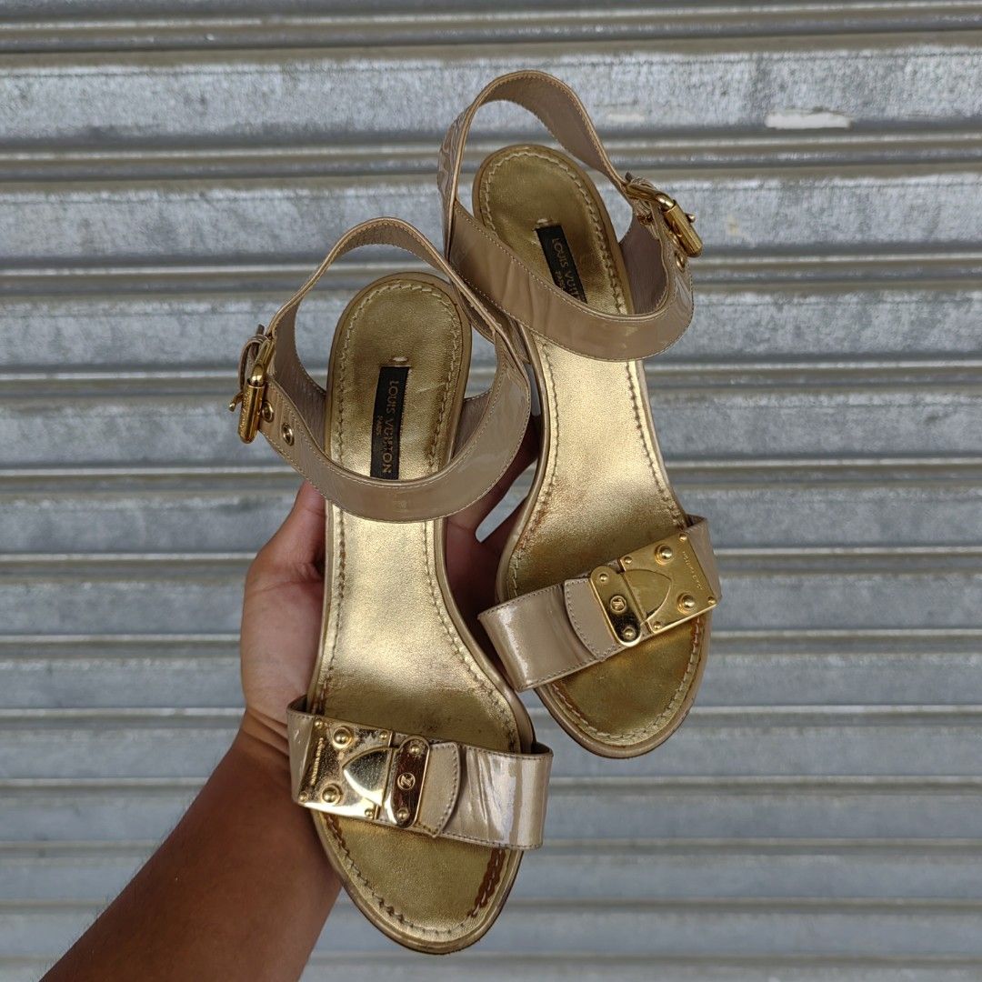 LOUIS VUITTON WEDGE SANDALS (Category: Wedges) located in Barotac Nuevo. Submitted by yorcollections (Listing ID 1469468535, Image 3). Description: LOUIS VUITTON WEDGE SANDALS Louis Vuitton ankle-belt patent leather wedge sandals in a metallic gold and beige tone, gold-tone lock hardware details on the front strap and ankle closure Size 37 on tag.
