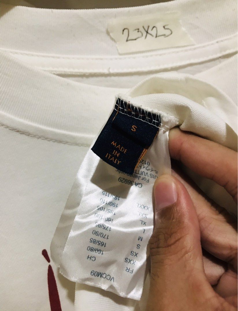 Louis Vuitton White T-Shirt Red Script Logo Size S (Category: Luxury Apparel) located in Rizal. Submitted by drthrifttwo (Listing ID 1469571943, Image 3). Description: - Brand: Louis Vuitton - Color: White with red handwritten script logo - Size: S (Relaxed fit) - Material: 100% Cotton, Made in Italy - Condition: Clean fabric with vibrant print - Style: Crewneck, short sleeves, streetwear staple.