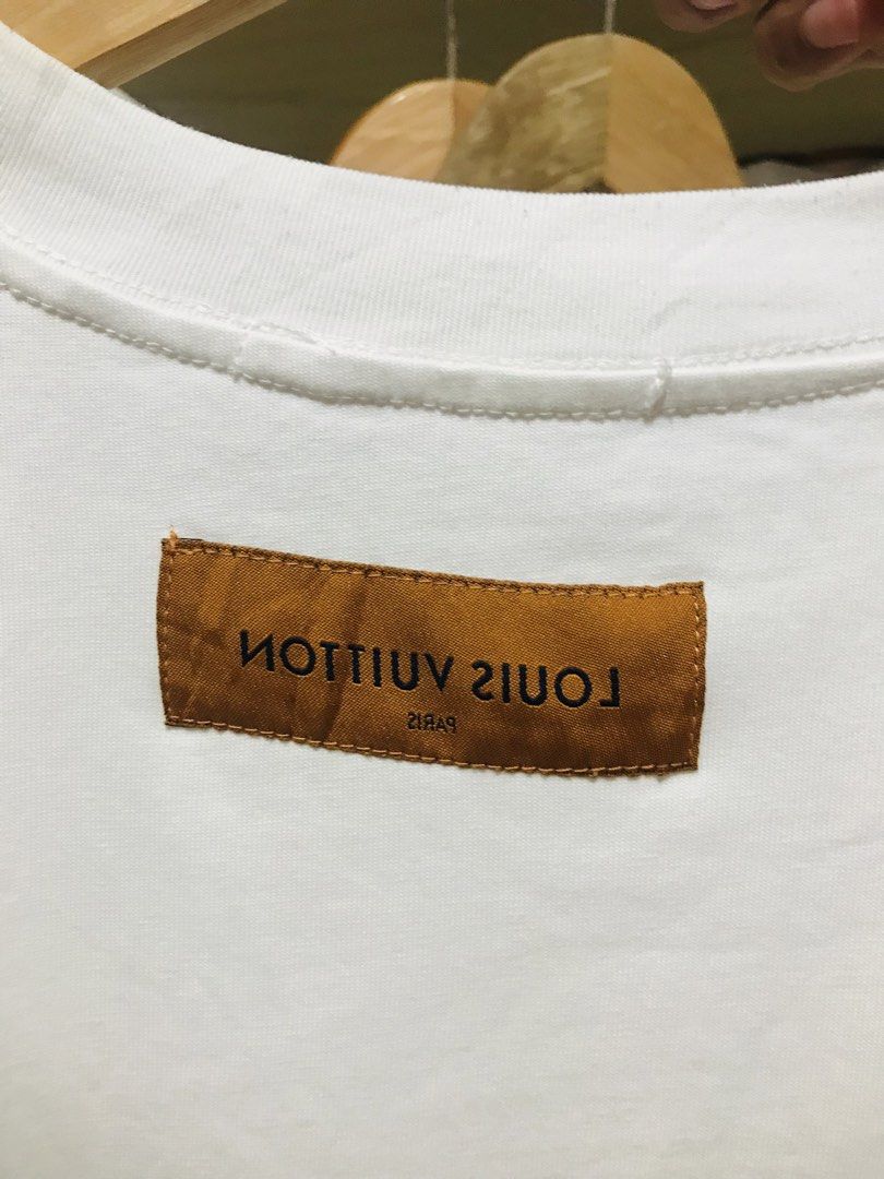 Louis Vuitton White T-Shirt Red Script Logo Size S (Category: Luxury Apparel) located in Rizal. Submitted by drthrifttwo (Listing ID 1469571943, Image 2). Description: - Brand: Louis Vuitton - Color: White with red handwritten script logo - Size: S (Relaxed fit) - Material: 100% Cotton, Made in Italy - Condition: Clean fabric with vibrant print - Style: Crewneck, short sleeves, streetwear staple.