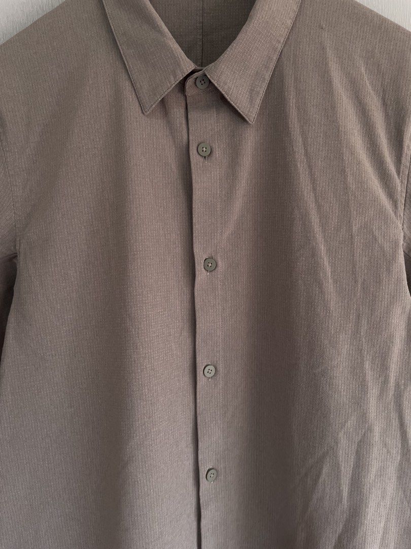 Lululemon Short Sleeve Button Up Shirt Brown Grid (Category: Tshirts & Polo Shirts ) located in Mataasnakahoy. Submitted by zero4thrift (Listing ID 1469429463, Image 3). Description: - Brand: Lululemon - Style: Brown grid-pattern short sleeve button-front shirt with classic collar - Fabric: Textured, lightweight material designed to keep you cool - Details: Subtle logo tag on the lower side seam, extra replacement button included - Condition: Exc