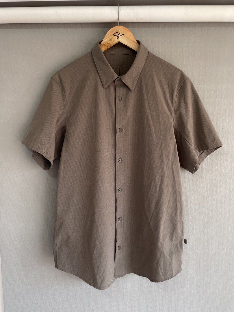 Lululemon Short Sleeve Button Up Shirt Brown Grid (Category: Tshirts & Polo Shirts ) located in Mataasnakahoy. Submitted by zero4thrift (Listing ID 1469429463, Image 1). Description: - Brand: Lululemon - Style: Brown grid-pattern short sleeve button-front shirt with classic collar - Fabric: Textured, lightweight material designed to keep you cool - Details: Subtle logo tag on the lower side seam, extra replacement button included - Condition: Exc