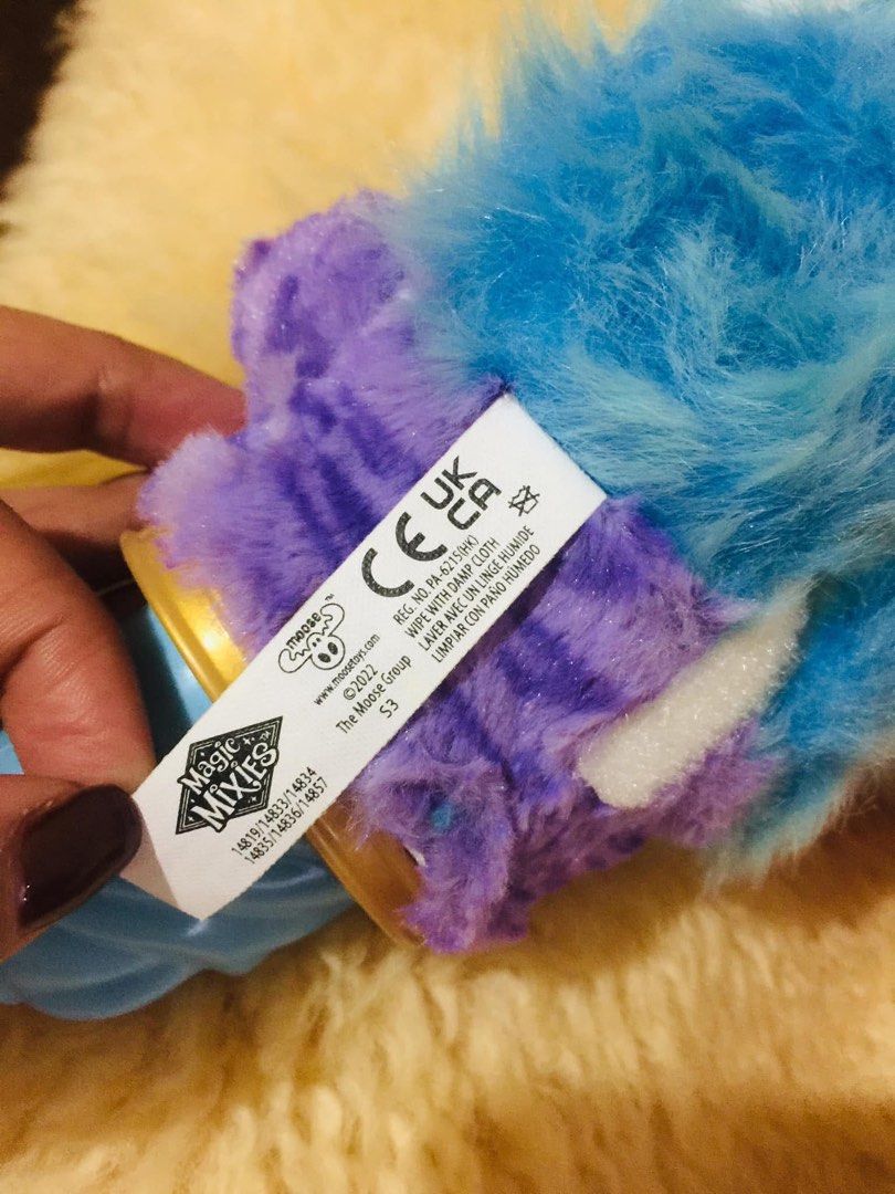 Magic Mixies Blue and Purple Interactive Toy (Category: Interactive Toys) located in Baguio. Submitted by izza_thrifty (Listing ID 1469515211, Image 3). Description: - Authentic Moose Toys Magic Mixies interactive plush (2022) - Soft blue and purple fur with white accents and big glittery pink/black eyes - Features a forehead gem and blue plastic tail base - Clean plush material with original tag attached - Working battery compartment secured wit