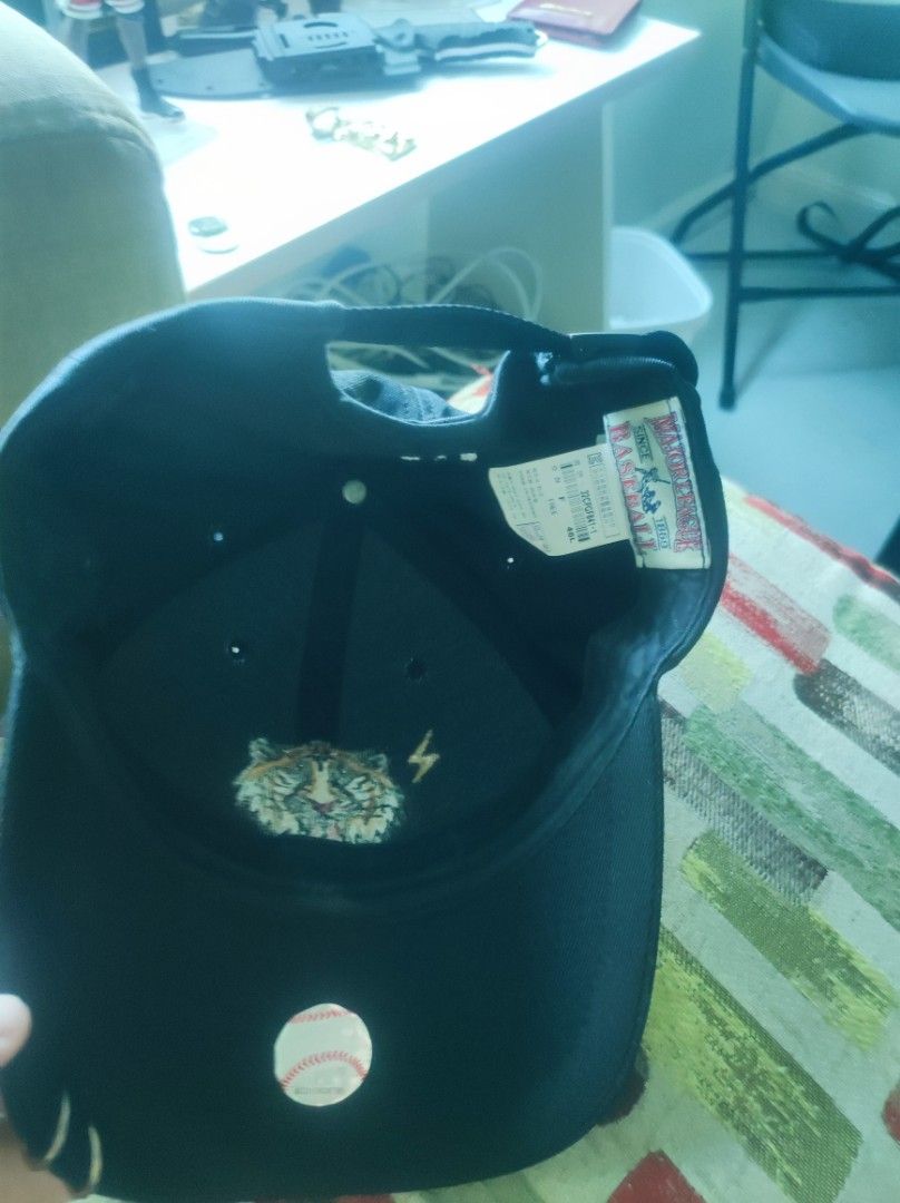 Major League Baseball MLB Tiger Embroidered Black Cap (Category: Caps & Hats) located in Pasay City. Submitted by wizemindz138970 (Listing ID 1469425911, Image 3). Description: - Color: Black - Design: Embroidered tiger face, lightning bolt graphic, and metal ring piercing on the brim - Fit: Free size with adjustable back strap closure - Authenticity: Inside tag features MLB branding and style code 32CPGF841-1 - Style: Casual street style authent