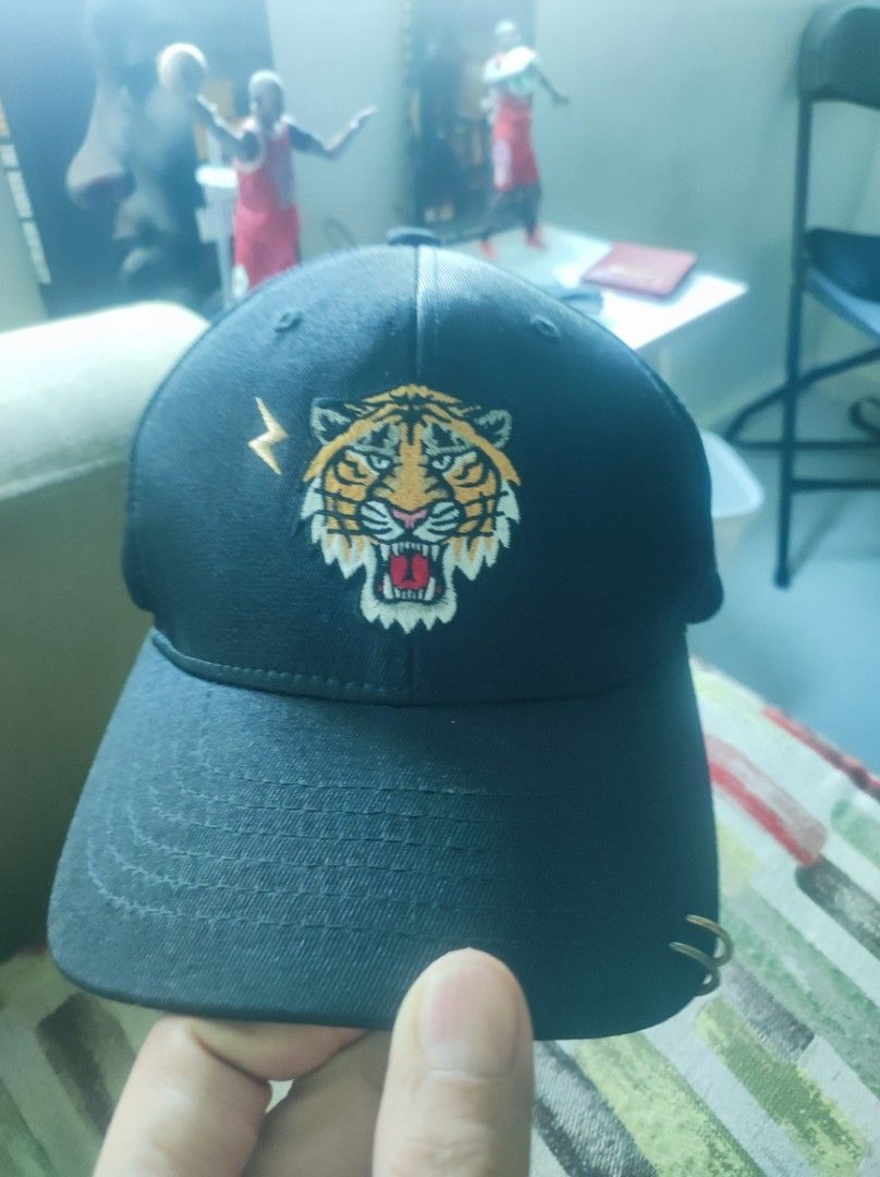 Major League Baseball MLB Tiger Embroidered Black Cap (Category: Caps & Hats) located in Pasay City. Submitted by wizemindz138970 (Listing ID 1469425911, Image 2). Description: - Color: Black - Design: Embroidered tiger face, lightning bolt graphic, and metal ring piercing on the brim - Fit: Free size with adjustable back strap closure - Authenticity: Inside tag features MLB branding and style code 32CPGF841-1 - Style: Casual street style authent